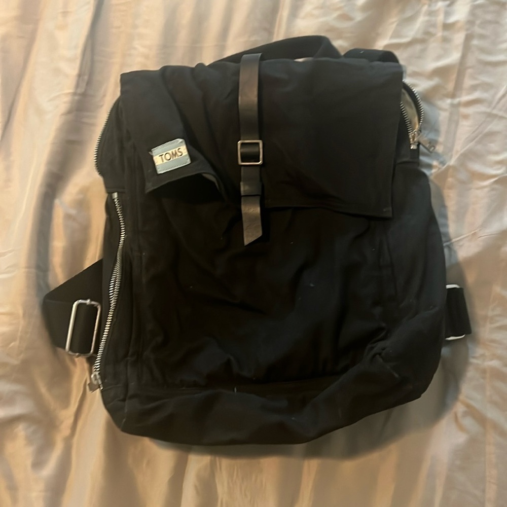 Tom’s black canvas backpack
